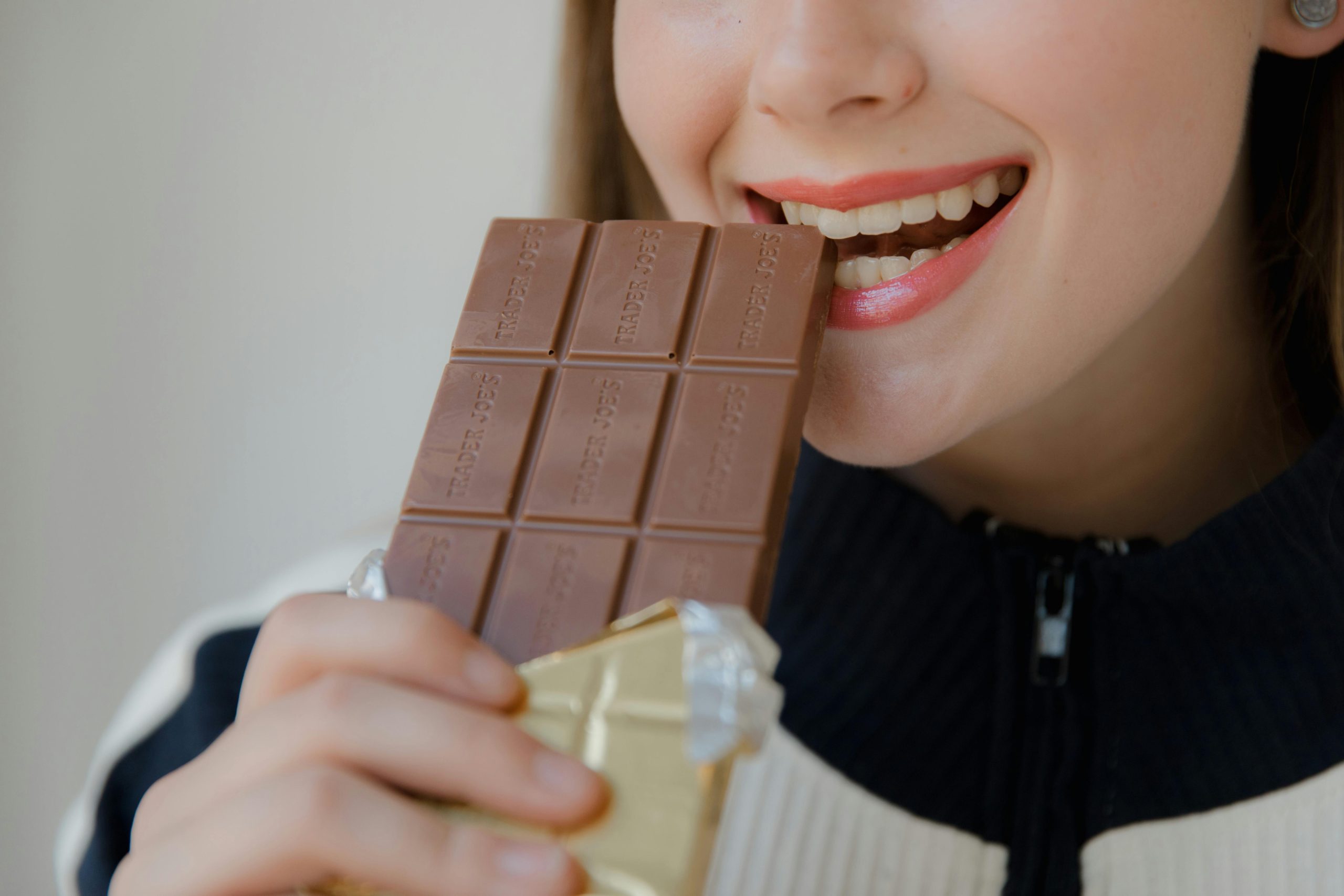woman biting a chocolate bar